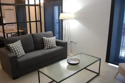 a living room with a couch and a glass table at Guesting Basílica in Jerez de la Frontera