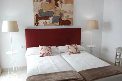 a bedroom with a white bed with two pillows at Guesting Basílica in Jerez de la Frontera