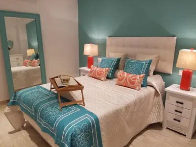 a bedroom with a bed with pillows and a mirror at AMAZING FRONTAL BEACH APARTMENT #Traveller's Awards2023 in Cádiz