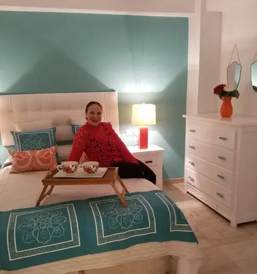a woman sitting on a bed in a bedroom at AMAZING FRONTAL BEACH APARTMENT #Traveller's Awards2023 in Cádiz