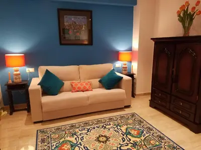 a living room with a couch with two pillows on it at AMAZING FRONTAL BEACH APARTMENT #Traveller's Awards2023 in Cádiz