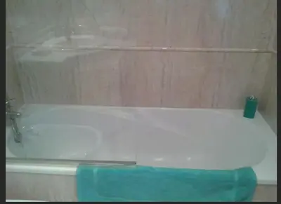 a bath tub with a faucet and a blue towel at AMAZING FRONTAL BEACH APARTMENT #Traveller's Awards2023 in Cádiz