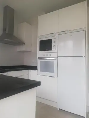 a kitchen with white appliances and white cabinets at Chalet Costa de la Luz - La Barrosa in Chiclana de la Frontera