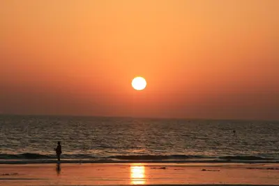 a person standing on the beach watching the sunset at Chalet Costa de la Luz - La Barrosa in Chiclana de la Frontera