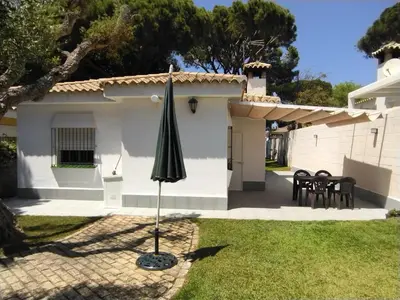 an umbrella in the yard of a house at Chalet Costa de la Luz - La Barrosa in Chiclana de la Frontera