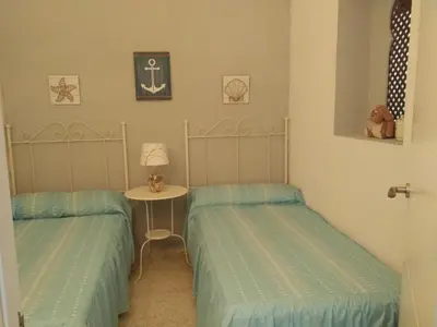 a room with two twin beds and a table at Carretera Pinar de los Franceses JAZMIN in Chiclana de la Frontera