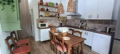 a kitchen with a wooden table and a kitchen with white cabinets at Carretera Pinar de los Franceses JAZMIN in Chiclana de la Frontera