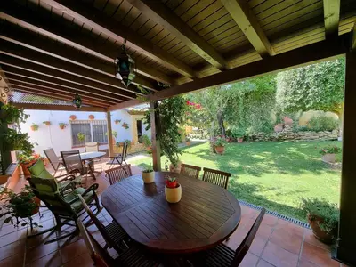 a wooden table and chairs on a patio at Carretera Pinar de los Franceses JAZMIN in Chiclana de la Frontera