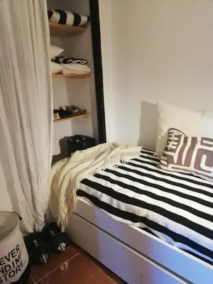 a bedroom with a bed and a shelf with shoes at Casa MariSol in Arcos de la Frontera