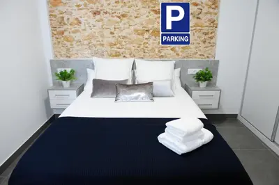 a bedroom with a large white bed with towels on it at LUZ DEL FARO in Cádiz