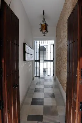 a hallway with wooden doors and a brick wall at LUZ DEL FARO in Cádiz