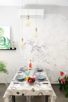 a dining room table with a white marble wall at LUZ DEL FARO in Cádiz