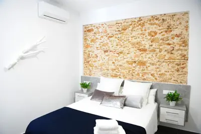 a bedroom with a bed and a brick wall at LUZ DEL FARO in Cádiz