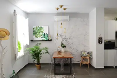 a dining room with a table and a marble wall at LUZ DEL FARO in Cádiz