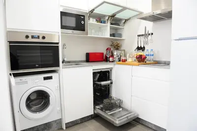 a white laundry room with a washer and dryer at LUZ DEL FARO in Cádiz
