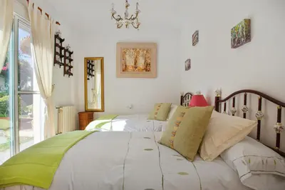a bedroom with two beds and a window at Charming villa in Sanlúcar de Barrameda with private pool in Sanlúcar de Barrameda