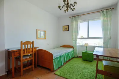 a bedroom with a bed and a desk and a window at Charming villa in Sanlúcar de Barrameda with private pool in Sanlúcar de Barrameda
