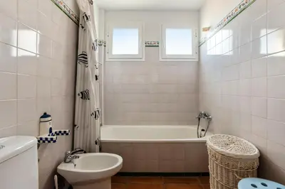 a bathroom with a tub and a toilet and a sink at Charming villa in Sanlúcar de Barrameda with private pool in Sanlúcar de Barrameda