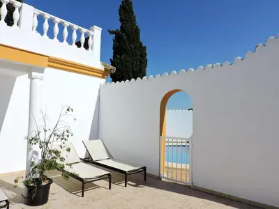 a white fence with two chairs and a door at Spacious Villa in Conil de Frontera with Private Pool in Roche