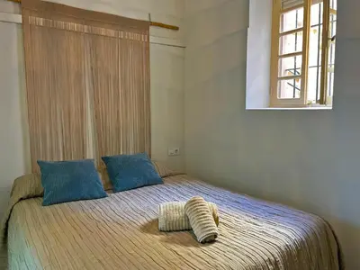a bedroom with a large bed with a window at Apartamento Vitoria. in Jerez de la Frontera