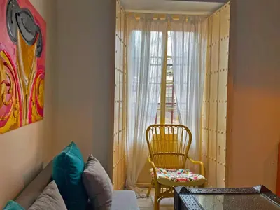 a living room with a couch and a chair and a window at Apartamento Vitoria. in Jerez de la Frontera