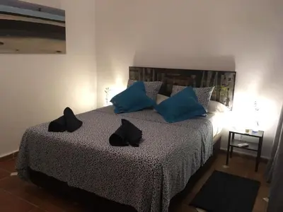a bedroom with a bed with blue and black pillows at Casa Maria in Rota