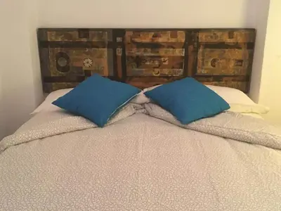 a bed with two blue pillows on top of it at Casa Maria in Rota