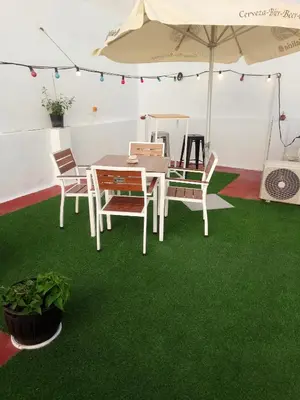 a table and chairs on green carpet in a tent at Casa Maria in Rota