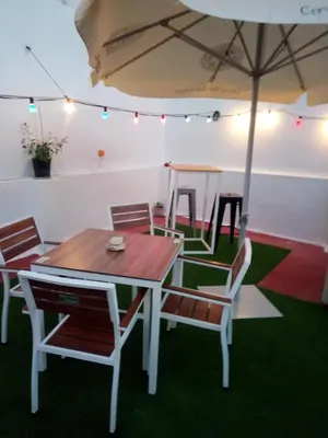 a table and chairs with an umbrella in a room at Casa Maria in Rota