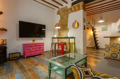 a living room with a glass table and a tv at Noah House city center - Historic center in Cádiz