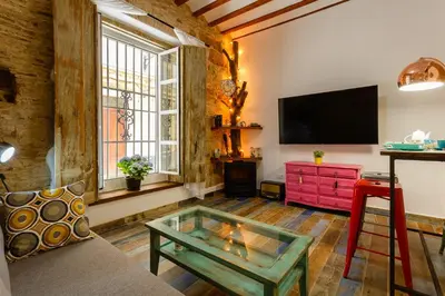 a living room with a glass coffee table and a tv at Noah House city center - Historic center in Cádiz