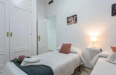 a white bedroom with two beds and a lamp at Centro 4 Rooms 3 baños Parking in Jerez de la Frontera