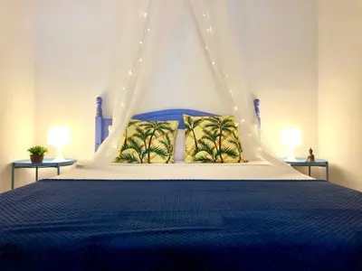 a bedroom with a blue bed with a canopy at GATU Verano en la playa con parking, wifi, piscina in El Puerto de Santa María