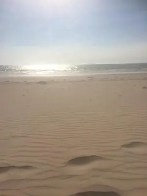 a sandy beach with the ocean in the background at GATU Verano en la playa con parking, wifi, piscina in El Puerto de Santa María