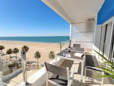 a balcony with a table and chairs and a beach at Apartamento Sea Views Rota in Rota