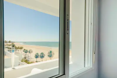 a window with a view of the beach at Apartamento Sea Views Rota in Rota