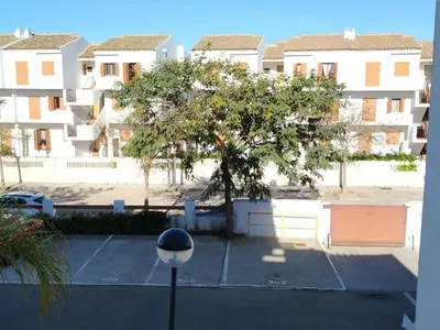 a tree in a parking lot in front of a building at APARTAMENTO EN COTO DE SANCTI PETRI in Chiclana de la Frontera