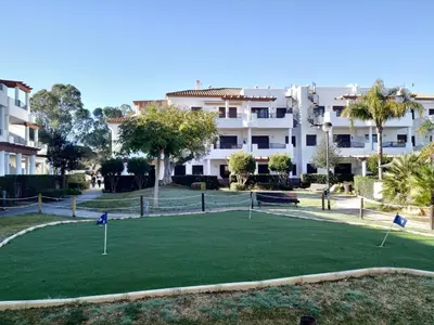 a golf course in front of a building at APARTAMENTO EN COTO DE SANCTI PETRI in Chiclana de la Frontera