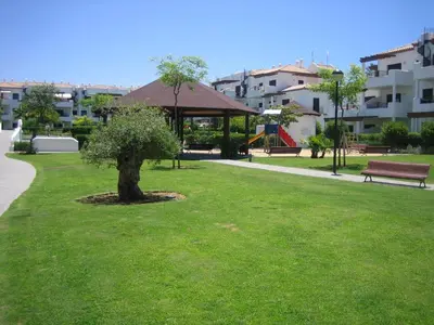 a park with a tree and a gazebo at APARTAMENTO EN COTO DE SANCTI PETRI in Chiclana de la Frontera