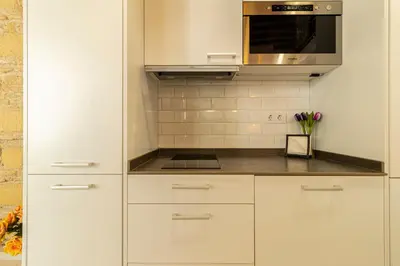 a kitchen with white cabinets and a microwave at Exclusive Boutique in Jerez de la Frontera