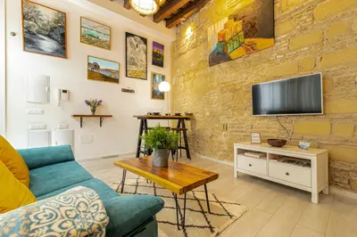 a living room with a couch and a tv on a brick wall at Exclusive Boutique in Jerez de la Frontera