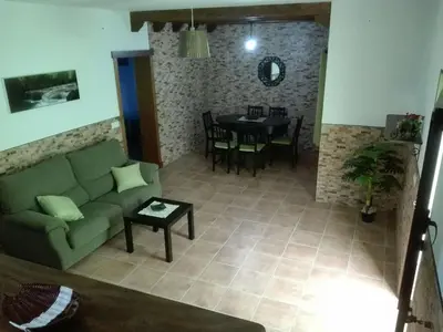 a living room with a green couch and a table at Casa 100m2 in Chiclana de la Frontera