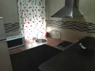a small kitchen with a sink and a microwave at Casa 100m2 in Chiclana de la Frontera
