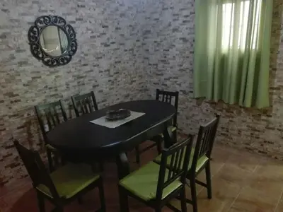 a dining room with a black table and chairs at Casa 100m2 in Chiclana de la Frontera