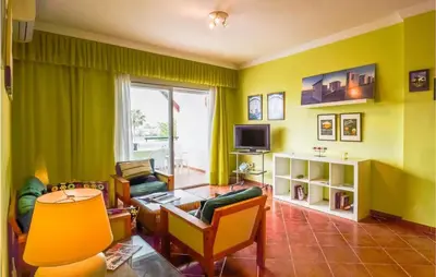 a living room with green walls and a table and chairs at Charming Apartment in Rota with Garden and Lake Views, 81 m² in Rota