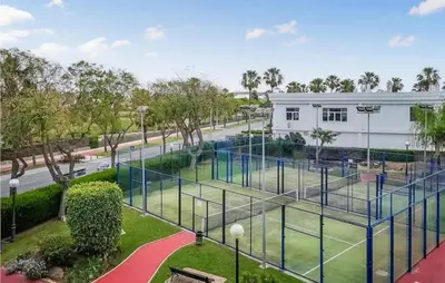 an empty tennis court in front of a building at Charming Apartment in Rota with Garden and Lake Views, 81 m² in Rota
