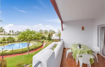 a balcony with a couch and a table and a pool at Charming Apartment in Rota with Garden and Lake Views, 81 m² in Rota