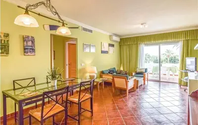 a dining room and living room with a table and chairs at Charming Apartment in Rota with Garden and Lake Views, 81 m² in Rota