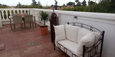 a couch on a balcony with a table and chairs at Room in Lovely cottage house Habitaciones en Chalet en Cadiz San Fernando in San Fernando