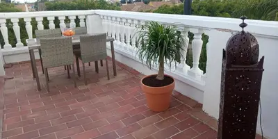 a table and chairs on a balcony with a potted plant at Room in Lovely cottage house Habitaciones en Chalet en Cadiz San Fernando in San Fernando